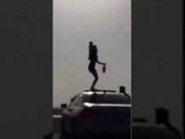 ‏فتاة تحمل زجاجة خمر وترقص على سقف سيارة بي أم دبليو