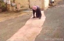وأبناؤه يفرشون له الطريق لتقيه حرارة الشمس